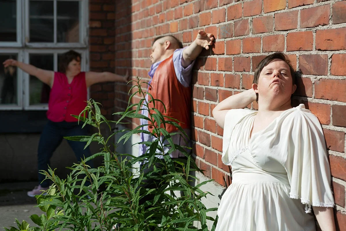 Tanssijat Sanna Tornikoski, Jarmo Patana ja Maria Lahti hyödyntävät rakennuksen tiiliseinää tanssissaan: he painautuvat ja nojautuvat vasten seinää.