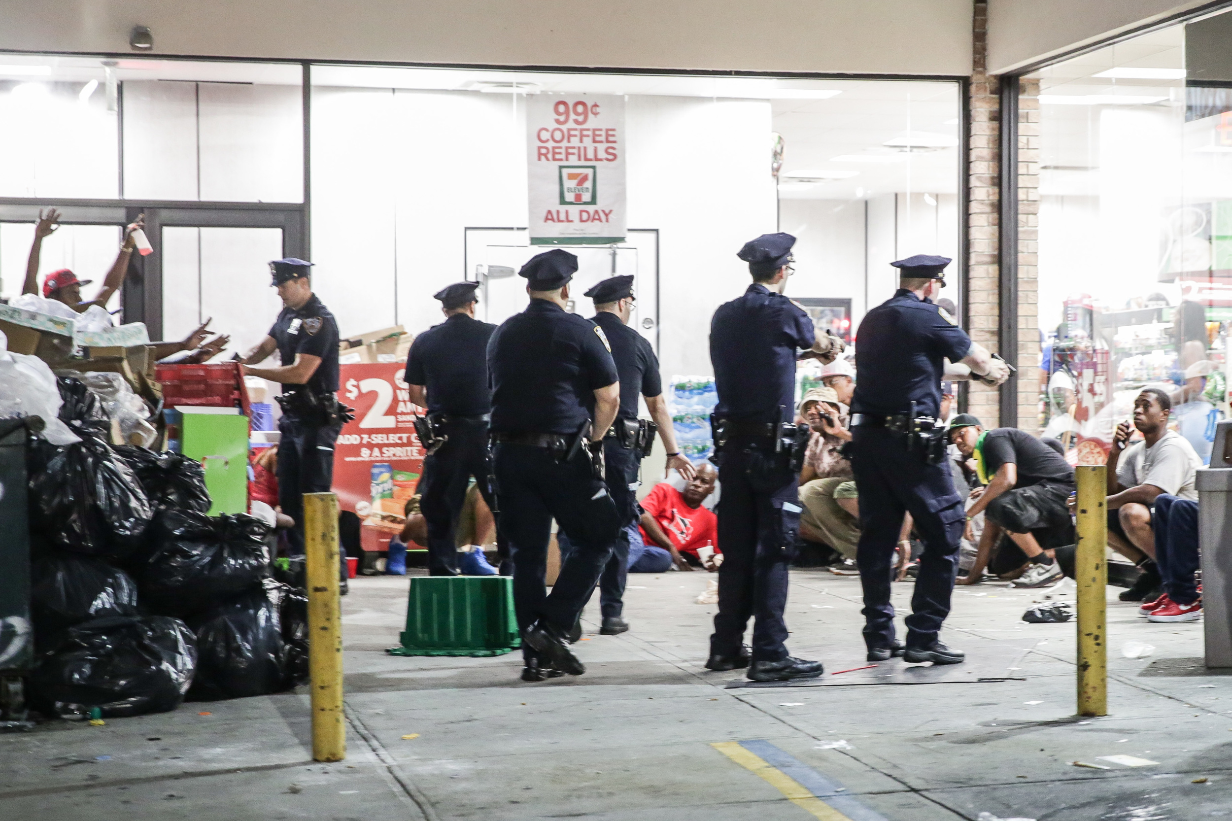  NYPD officers draw their guns after gunshots were heard in Crown Heights, Brooklyn during J'Ouvert, an overnight celebration before the West Indian Day Parade 