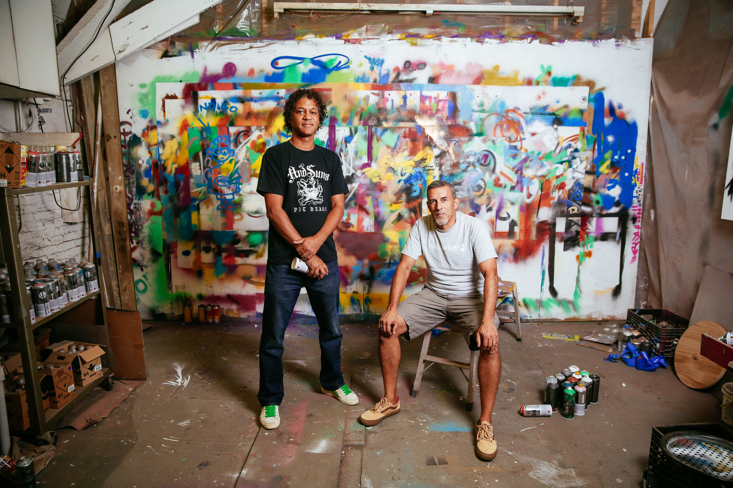  NYC graffiti artists Crash (l) and Daze (r) in front of a wall covered in excess spray paint in their studio in the South Bronx, NY. 