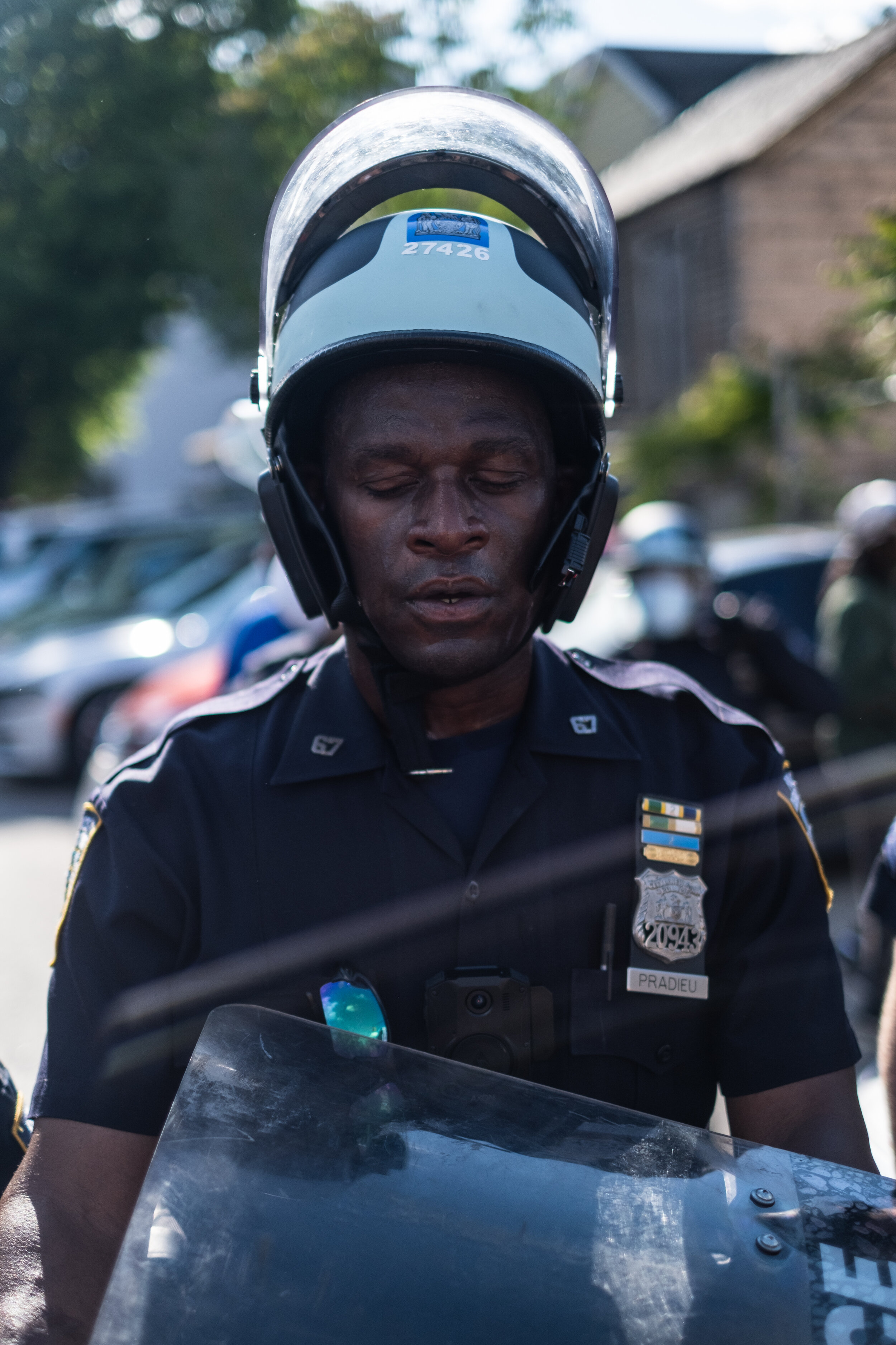  May 30, 2020: New York, NY -   A police officer takes a deep breath after Protesters clash with NYPD officers outside of the 67th precinct in Brooklyn after George Floyd was killed while being detained by Minneapolis police on May 25.  
