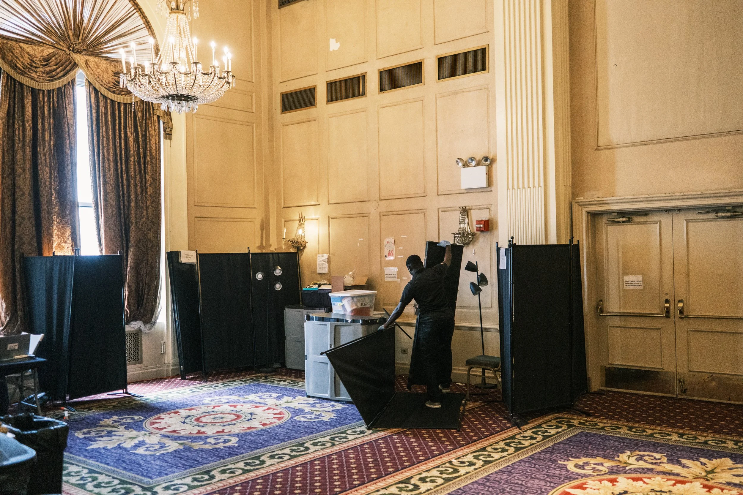 A worker breaks down part of the medical exam area on the last day of the Arrival Center