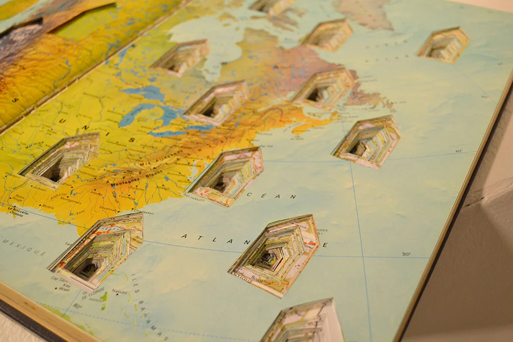 altered book atlas with houses cut out