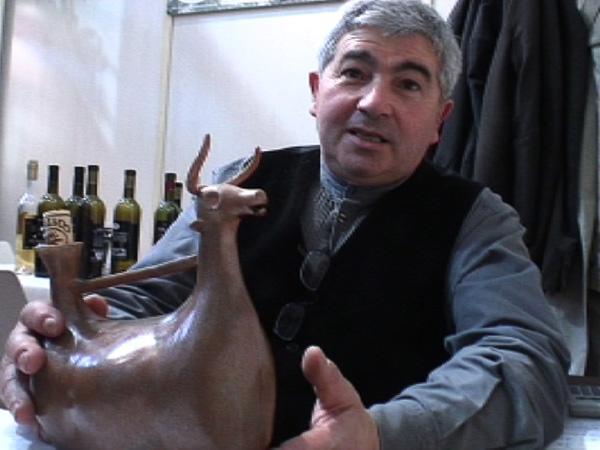 Tonino Arcadu con in mano una riproduzione moderna di un askos , in questo caso contenente il Vino Nuragico presentato al Vinitaly