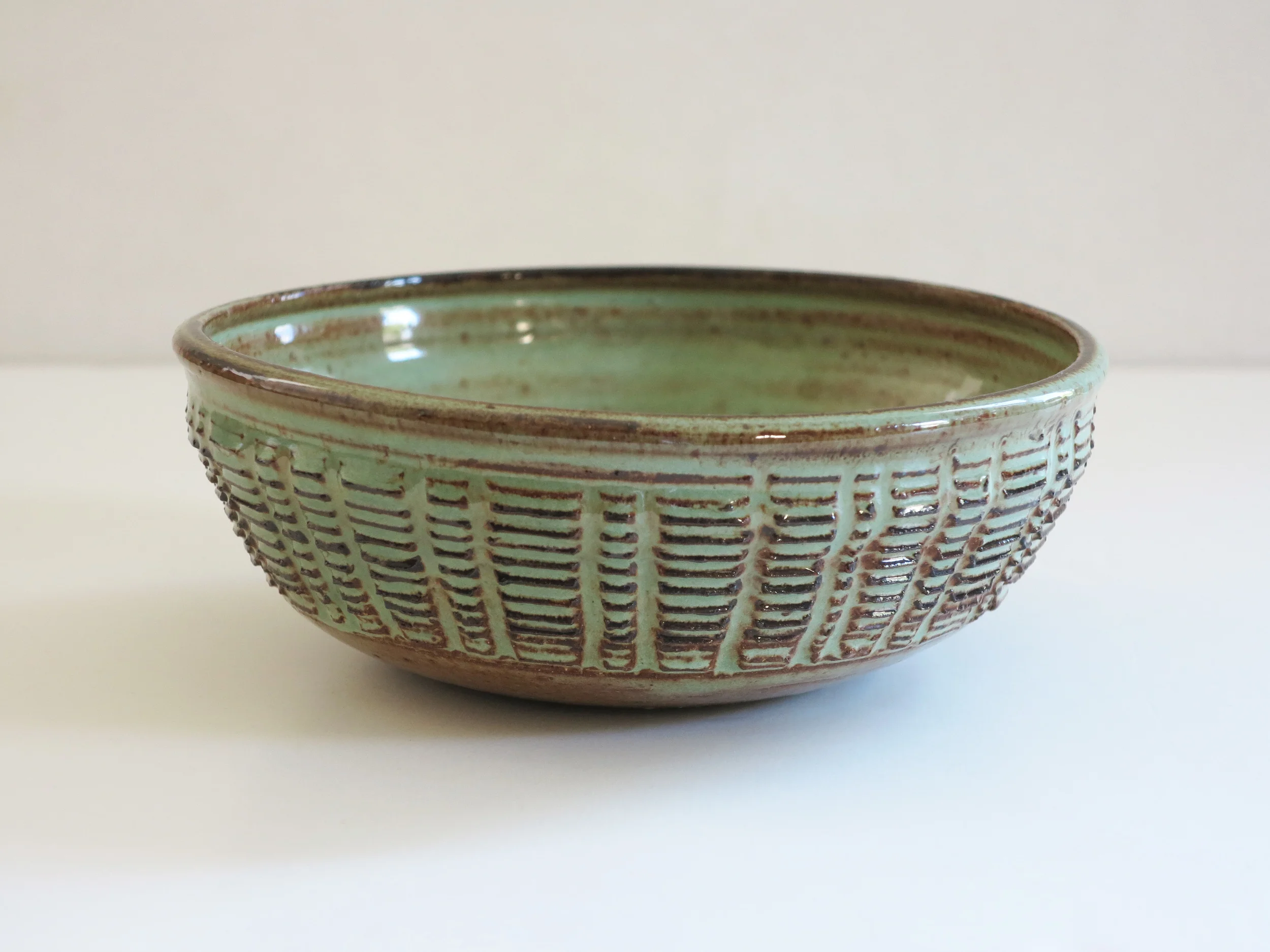 A c1960 incised stoneware bowl by Nancy Wickham (1923-1987). 7.5" dia. 2.5" h.