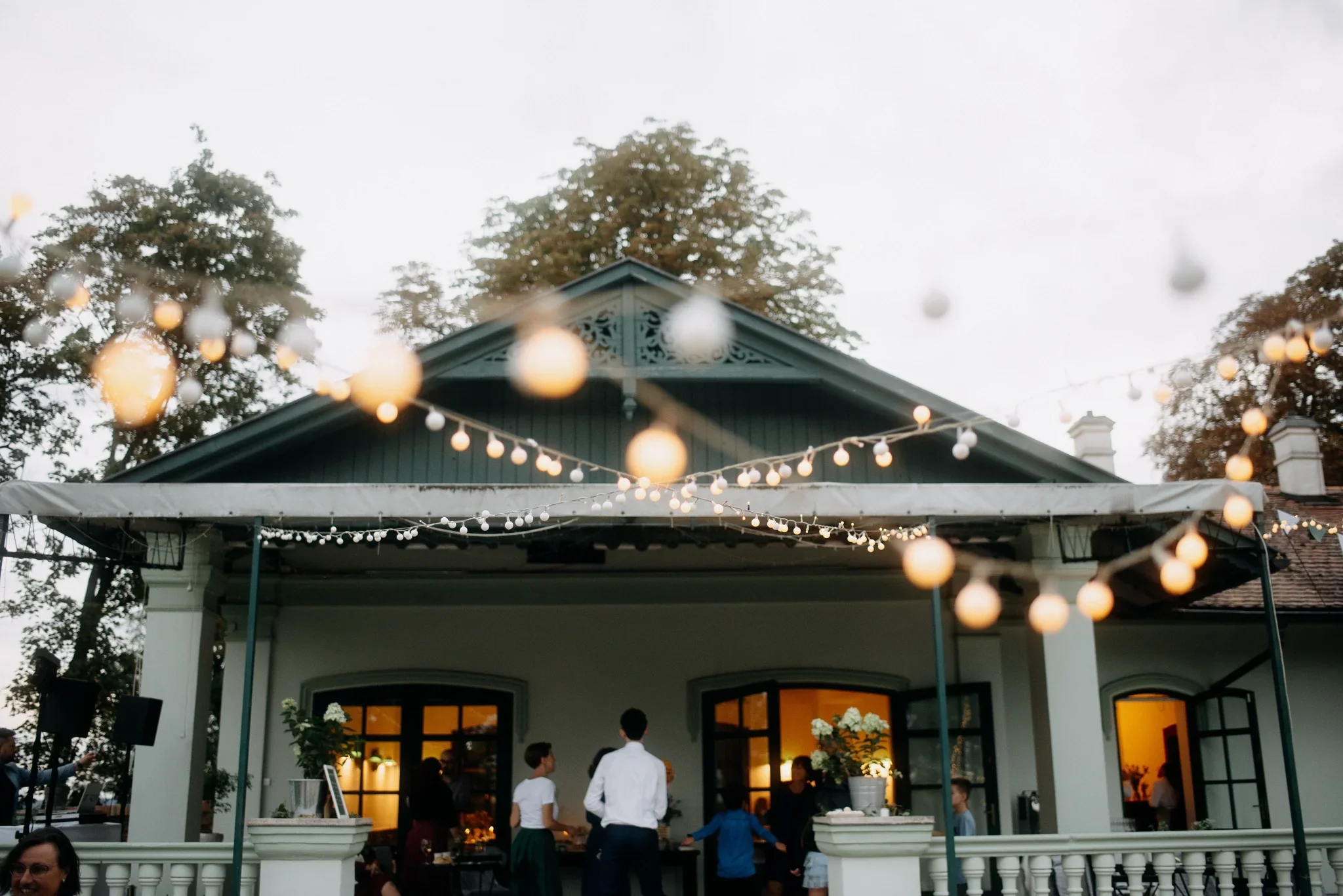 Svatební hostina na verandě dřevěného pavilonu Hlídka na Špilberku se světelnými řetězy, svatba v Brně