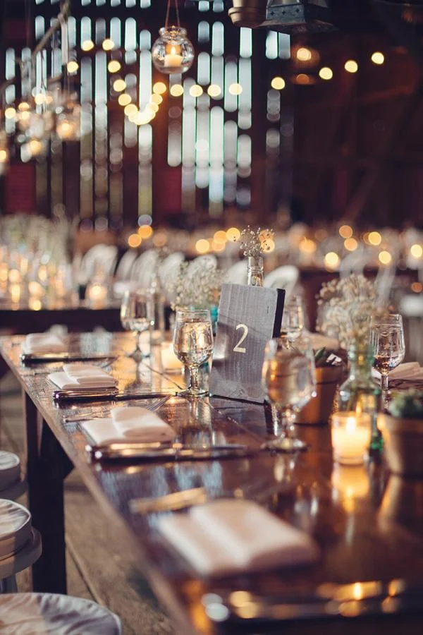 Barnes Farm Tables event setup with farmhouse tables, chairs, and string lighting at an outdoor reception