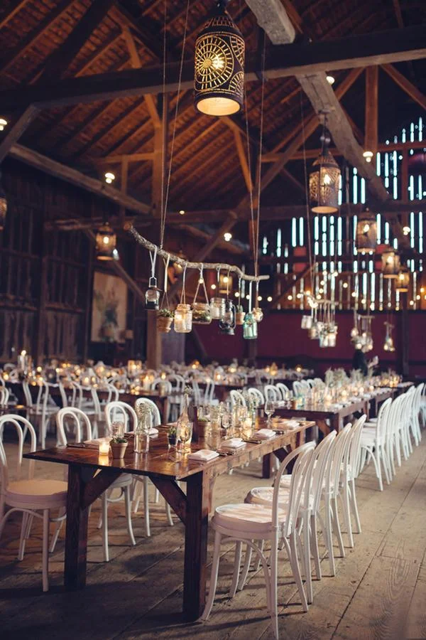 String lights and hanging fixtures at a barn reception
