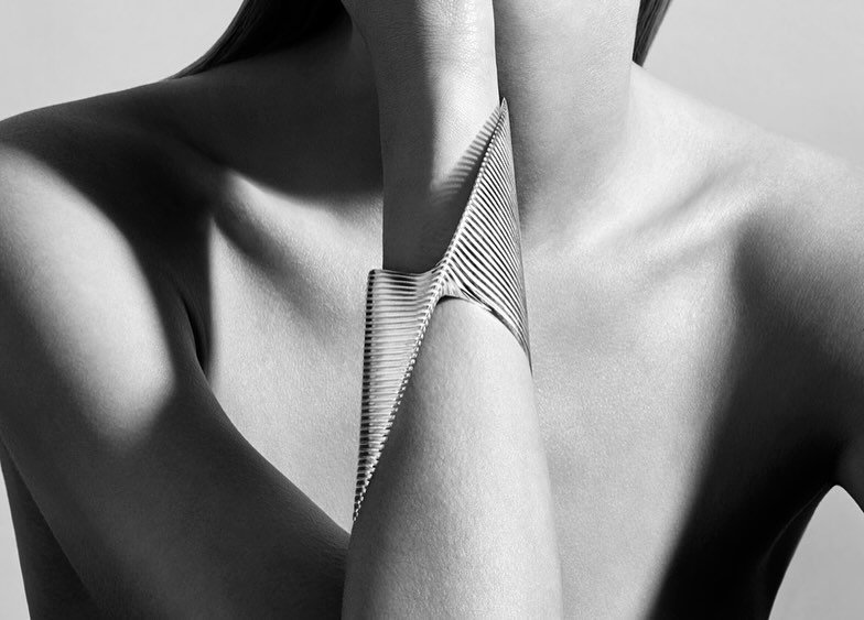 Zaha Hadid translates the iconic curves of her architectural marvels into a jewelry collection for Georg Jensen. Featuring a uniquely twisted silver cuff and a bold double-finger ring, each piece mirrors the sculptural beauty of Hadid&rsquo;s renowne