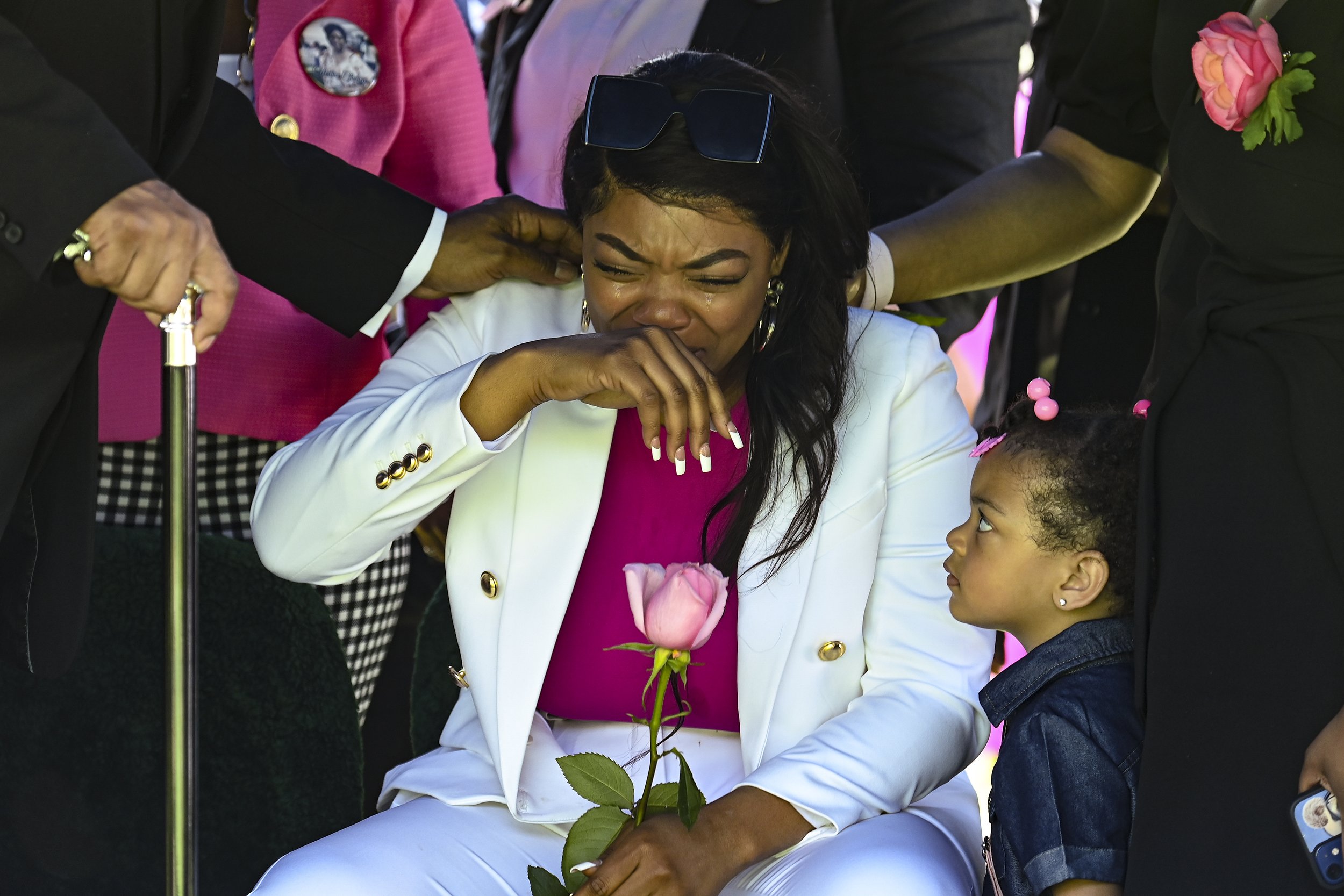  Kayla Jones, granddaughter of Celestine Chaney becomes emotional as her niece, Layonna Rivera looks up at her while Celestine Chaney’s casket is lowered into the ground. Jones was very close to her grandmother. 