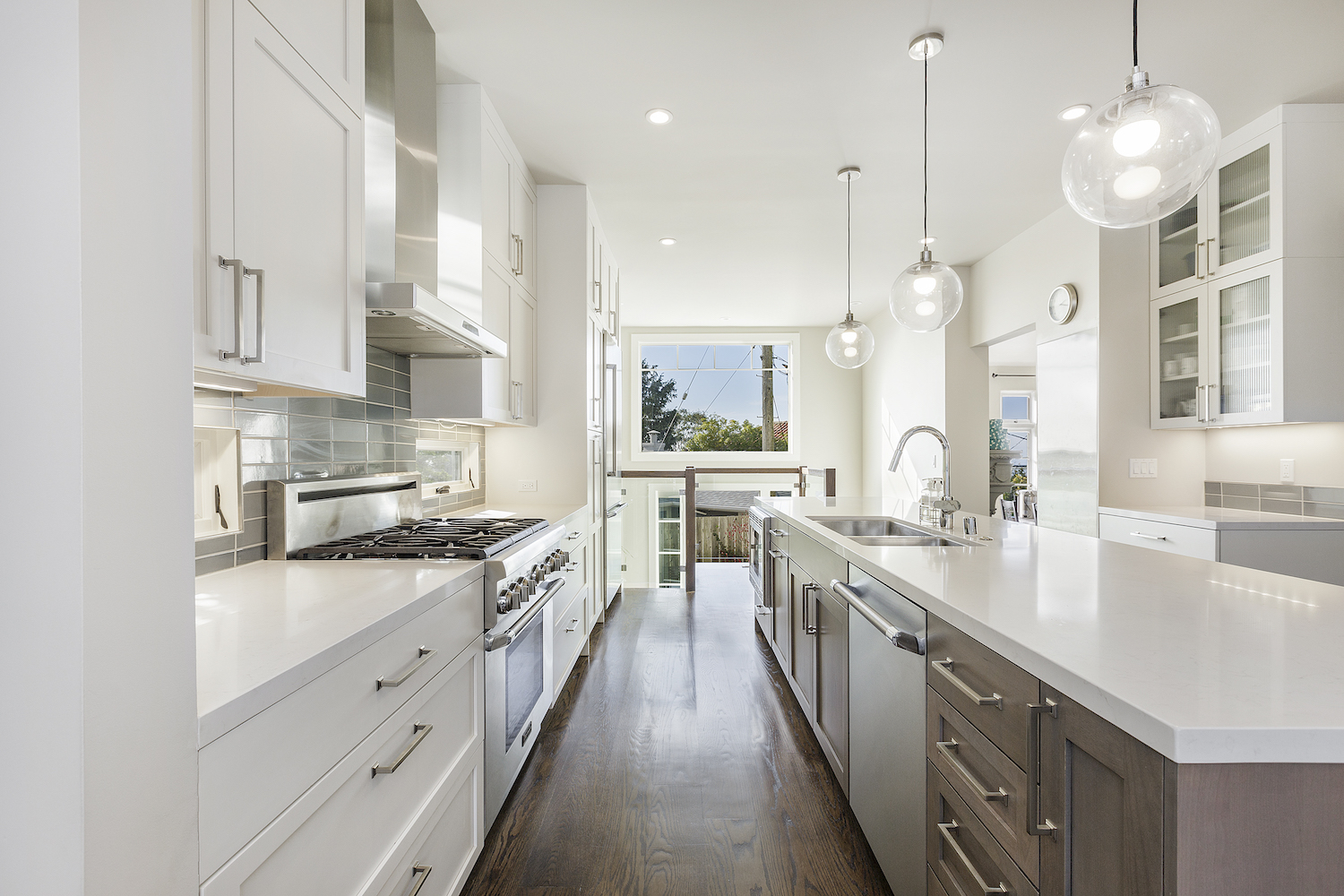 kitchen with white cabinets and wood flooring and stainless steel appliances.jpg