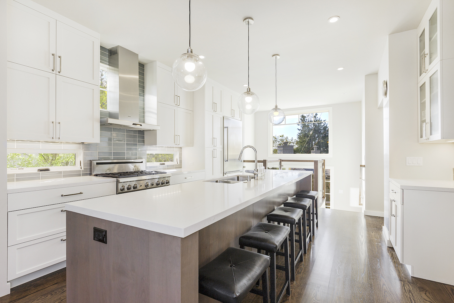 white kitchen with brown wood island and wood flooring and stainless steel appliances.jpg