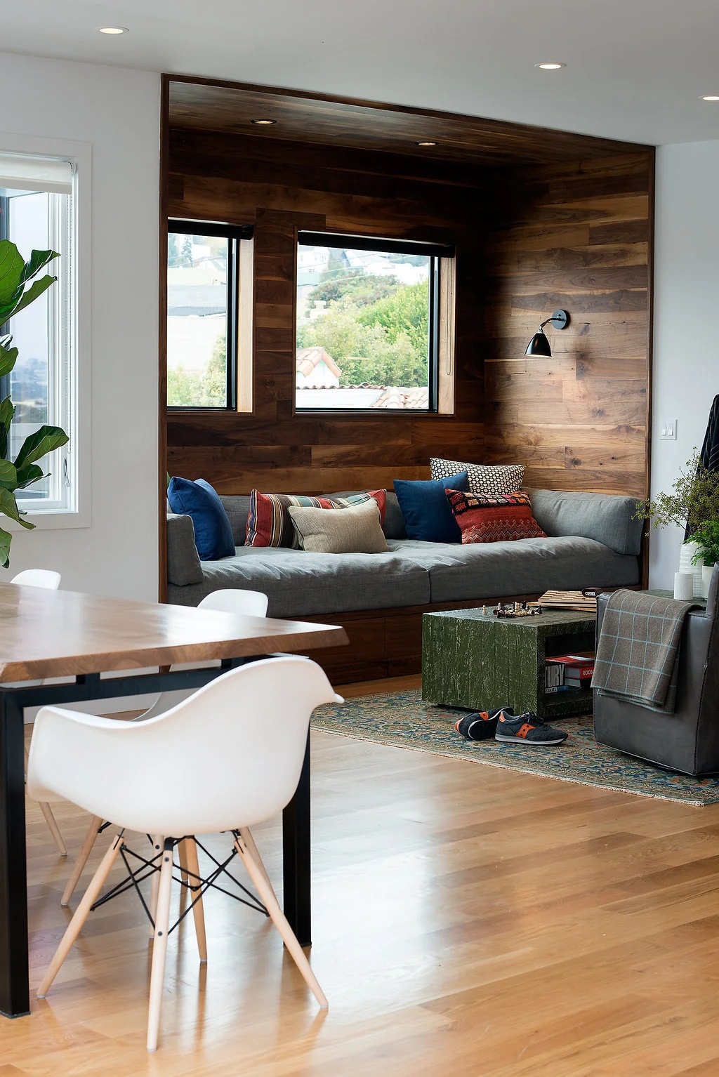 living dining area with custom built in seating and wood table with white chairs and wood flooring.jpg