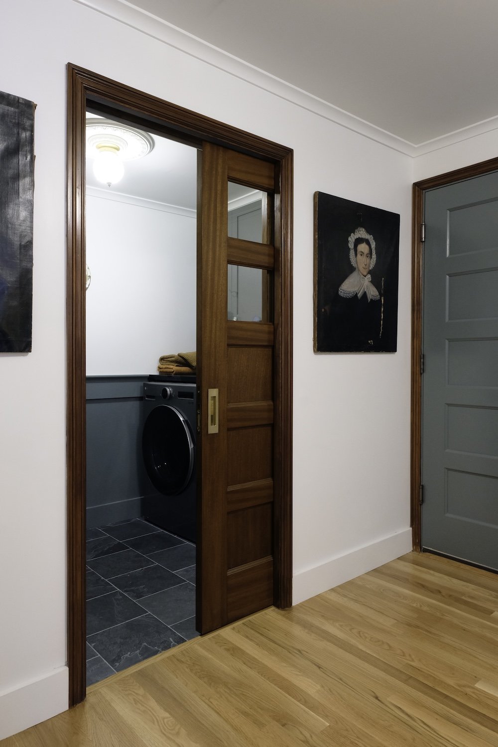 laundry room with green wainscoting and stain grade pocket door.jpg