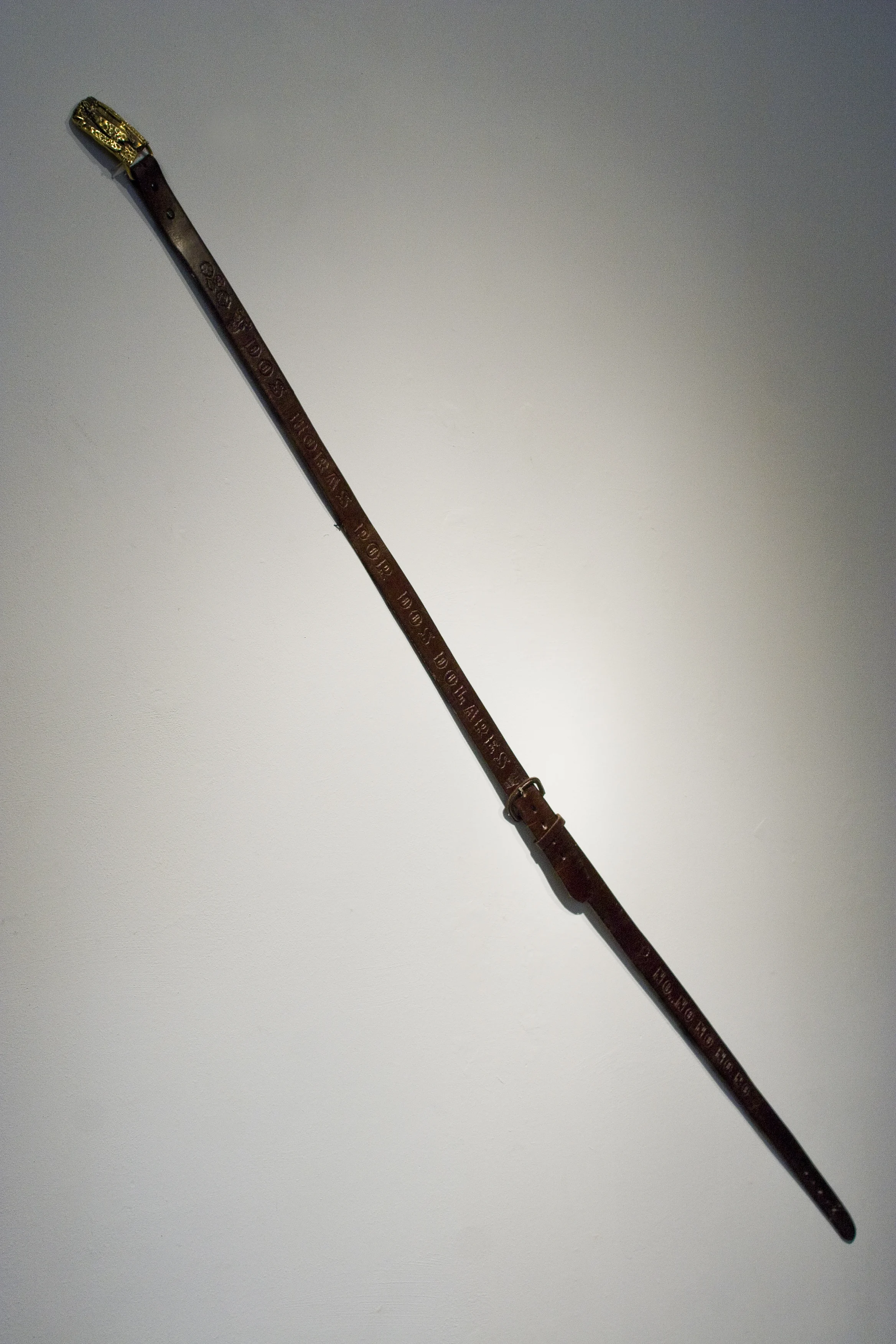 Dos dolares por dos horas and Daley's son, Leather belts, bronze belt buckle, stamped text and iconography, 76 X 3 inches, 2007