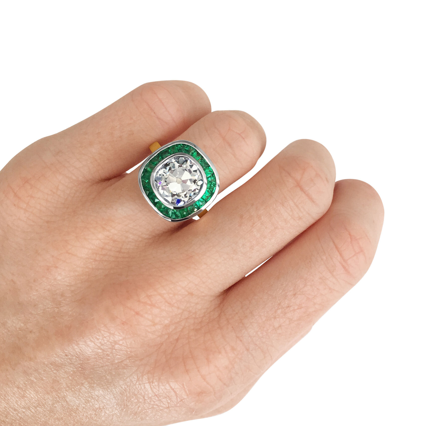 Old cut cushion-cut diamond target ring with emerald halo mounted in 18ct yellow gold. 