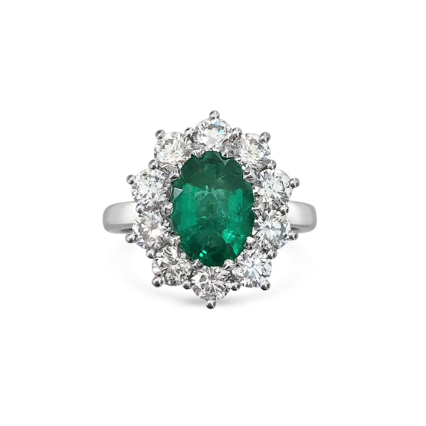 Oval emerald with diamond halo engagement ring, mounted in platinum.
