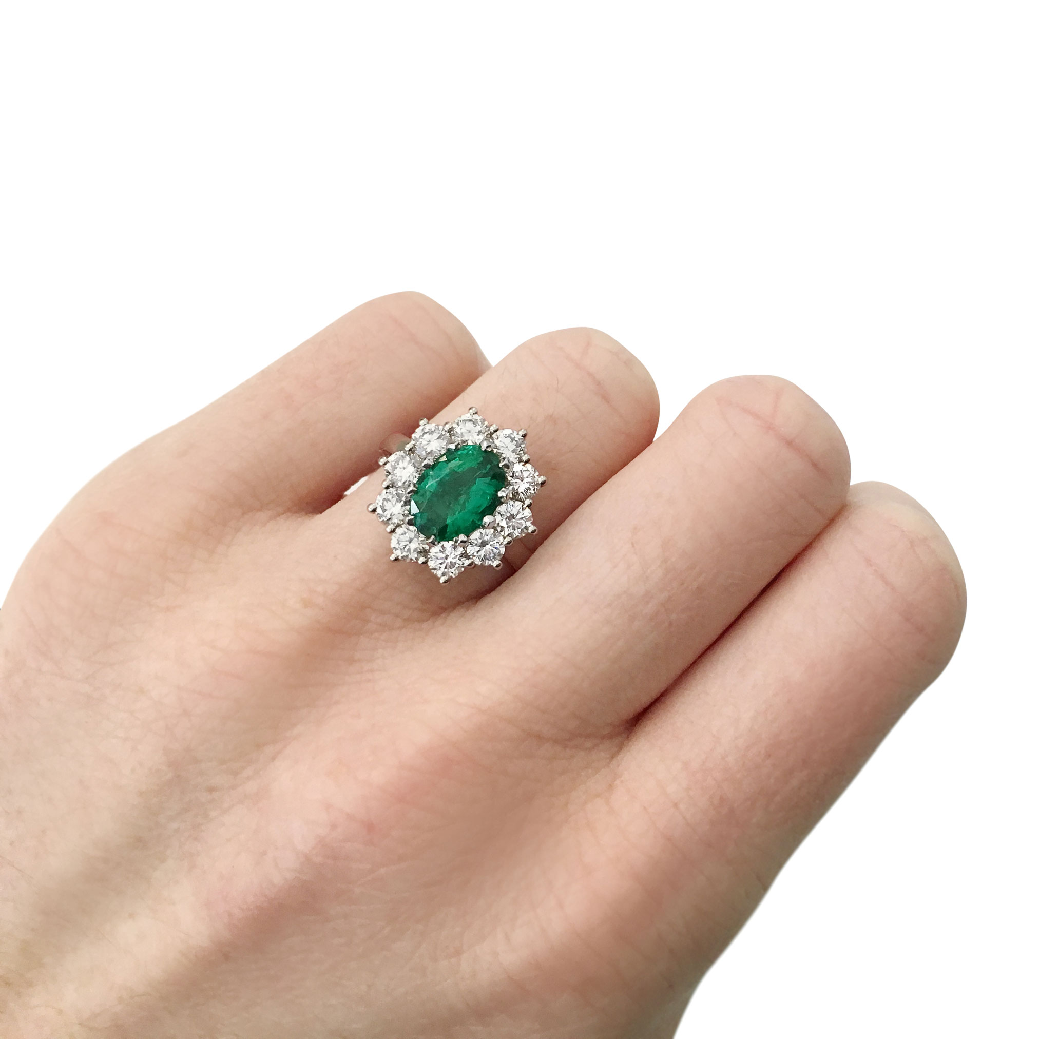 Oval emerald with diamond halo engagement ring, mounted in platinum.
