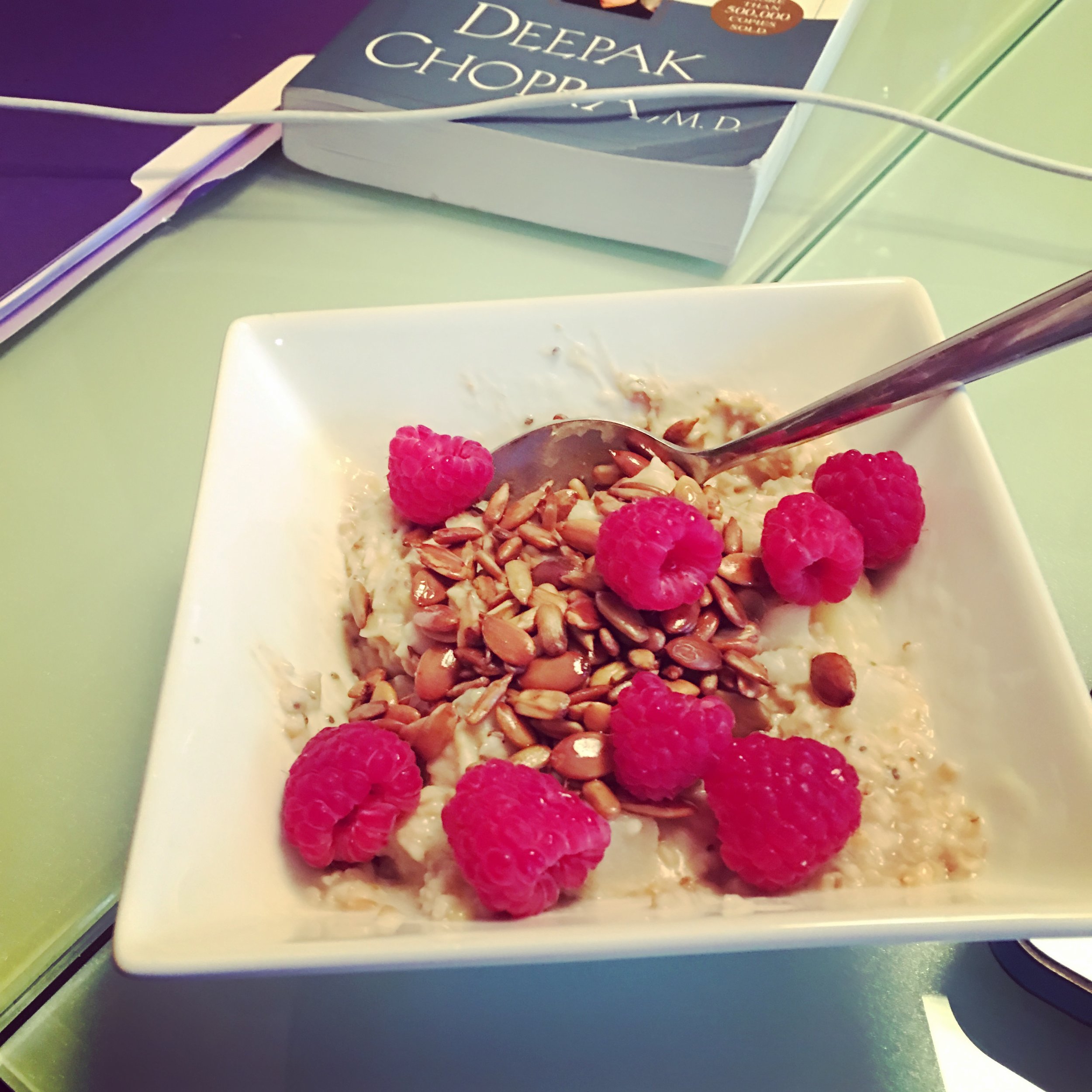  Steel cut oats with pears, toasted sunflower and pumpkin seeds, cashew butter, chia seeds and raspberries. Deepak's book  Perfect Health  in the background.  