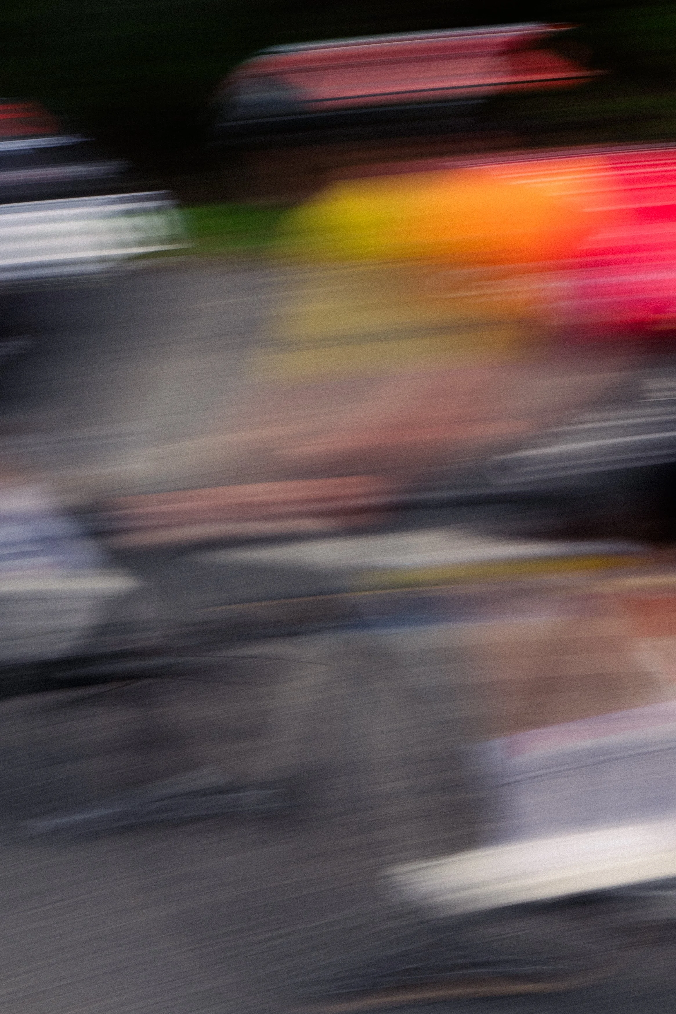 Blurred image of parked bikes and vehicles.