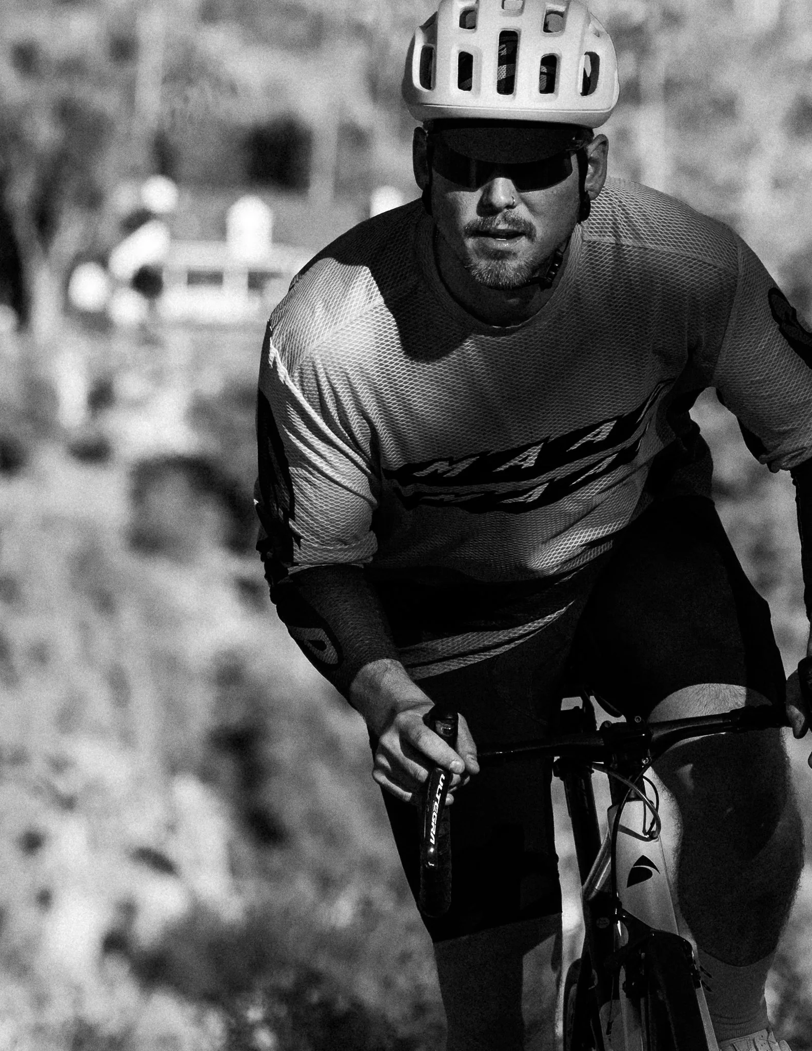 A man wearing a helmet and sunglasses riding a mountain bike outdoors.