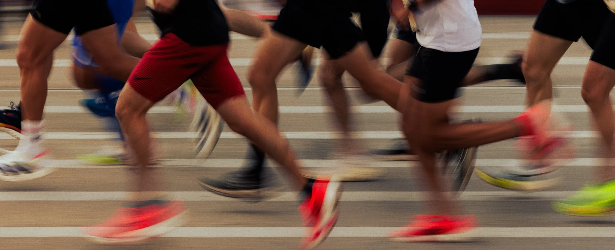 People running in a race on an indoor track.