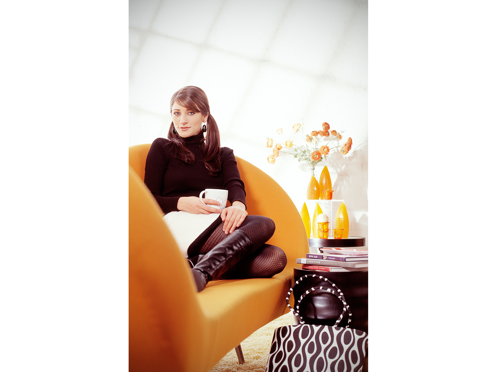 Woman drinking coffee on modern orange couch for coffee maker ad