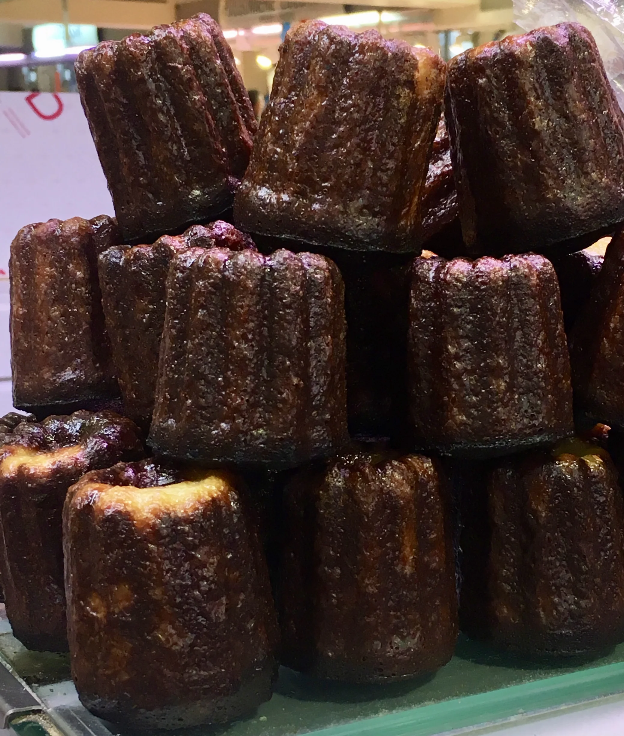 The cannele bordelais is the local confection of the Bordeaux region. It's a cake with a rich custard interior enclosed in a thin caramelized cake shell baked in a copper fluted molds which gives it a unique shape. The tale of its origin is a bit unclear but two versions that seem to have the most credence are 1) nuns from a convent in Bordeaux (before the French Revolution) prepared cakes made from donated egg yolks from local winemakers who needed only egg whites to clarify their wines and 2) residents who lived along the river Garonne gathered spilt low-protein flour from the loading docks then used it to make sweets for poor children. The cakes come in a variety of sizes but the traditional size is small enough to fit in the palm of your hand and enjoy with a cup of coffee or glass of wine.