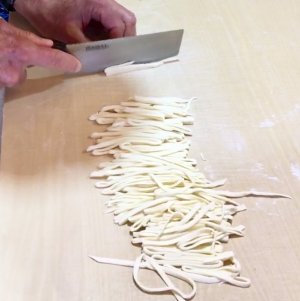 Slicing dough into noodles