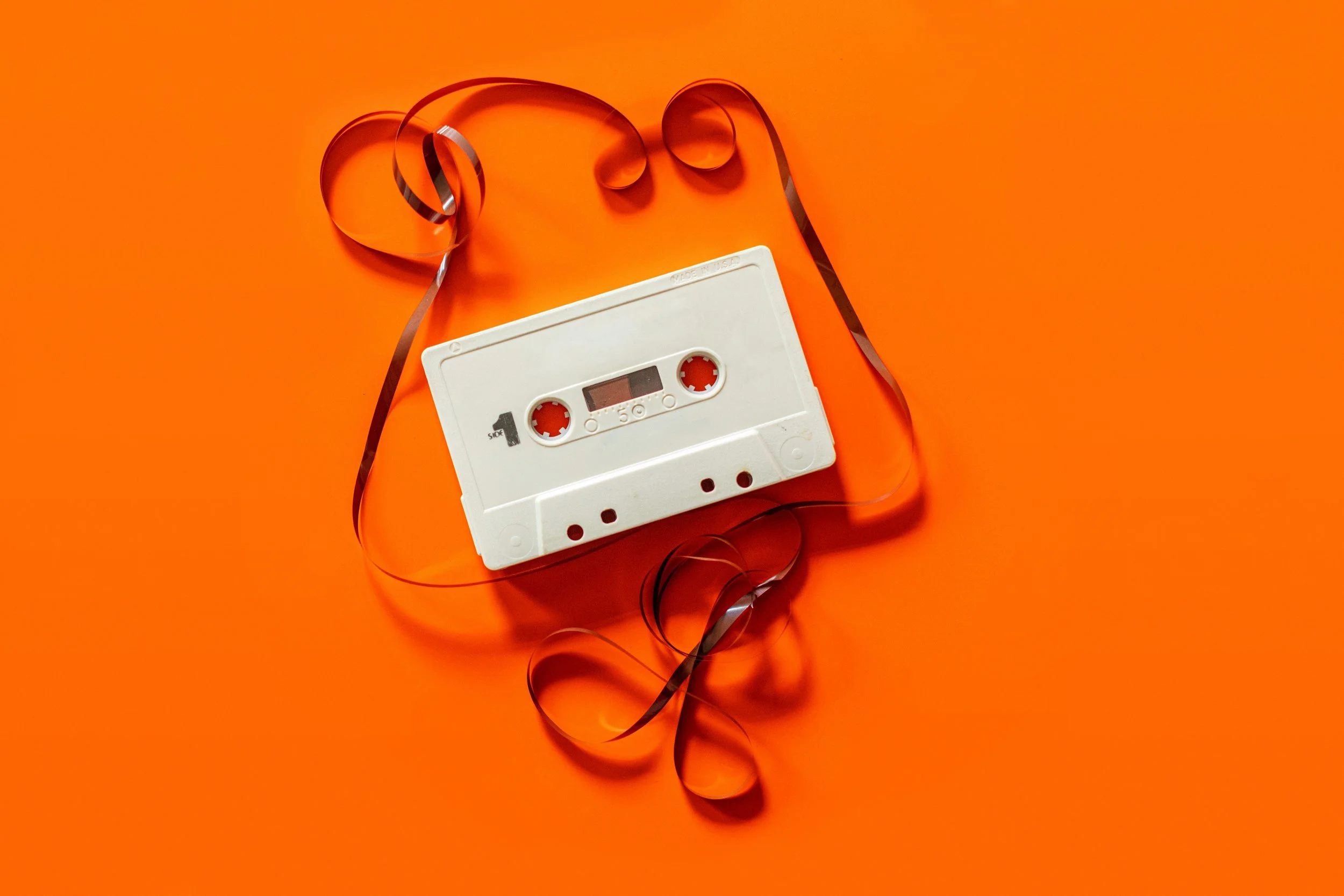 Orange background with unwound white cassette