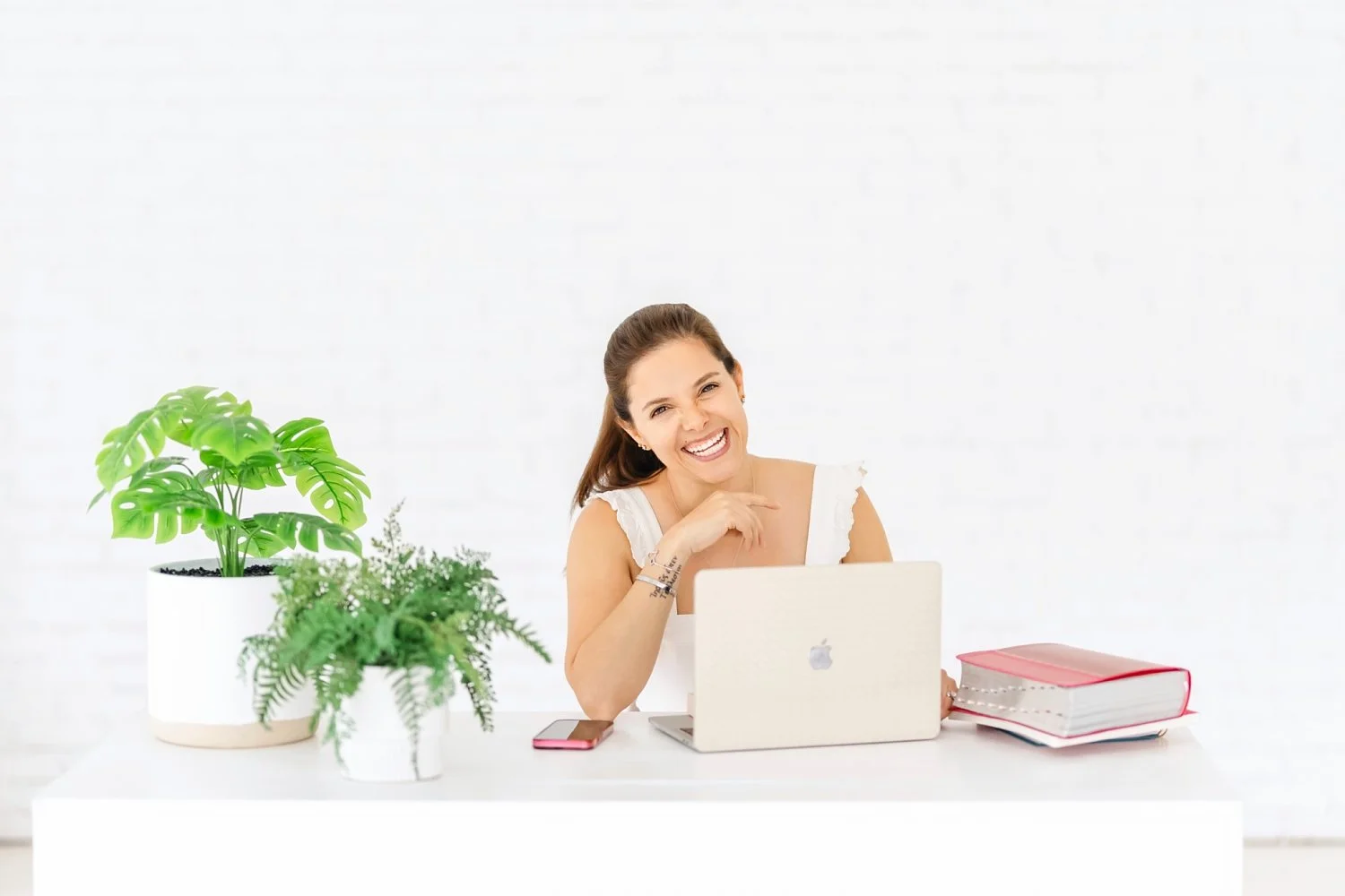 business owner poses with laptop and desk office area