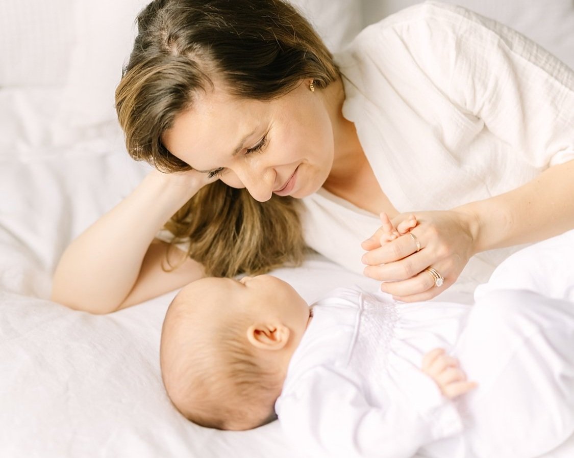 mom with baby girl taking newborn photos at home