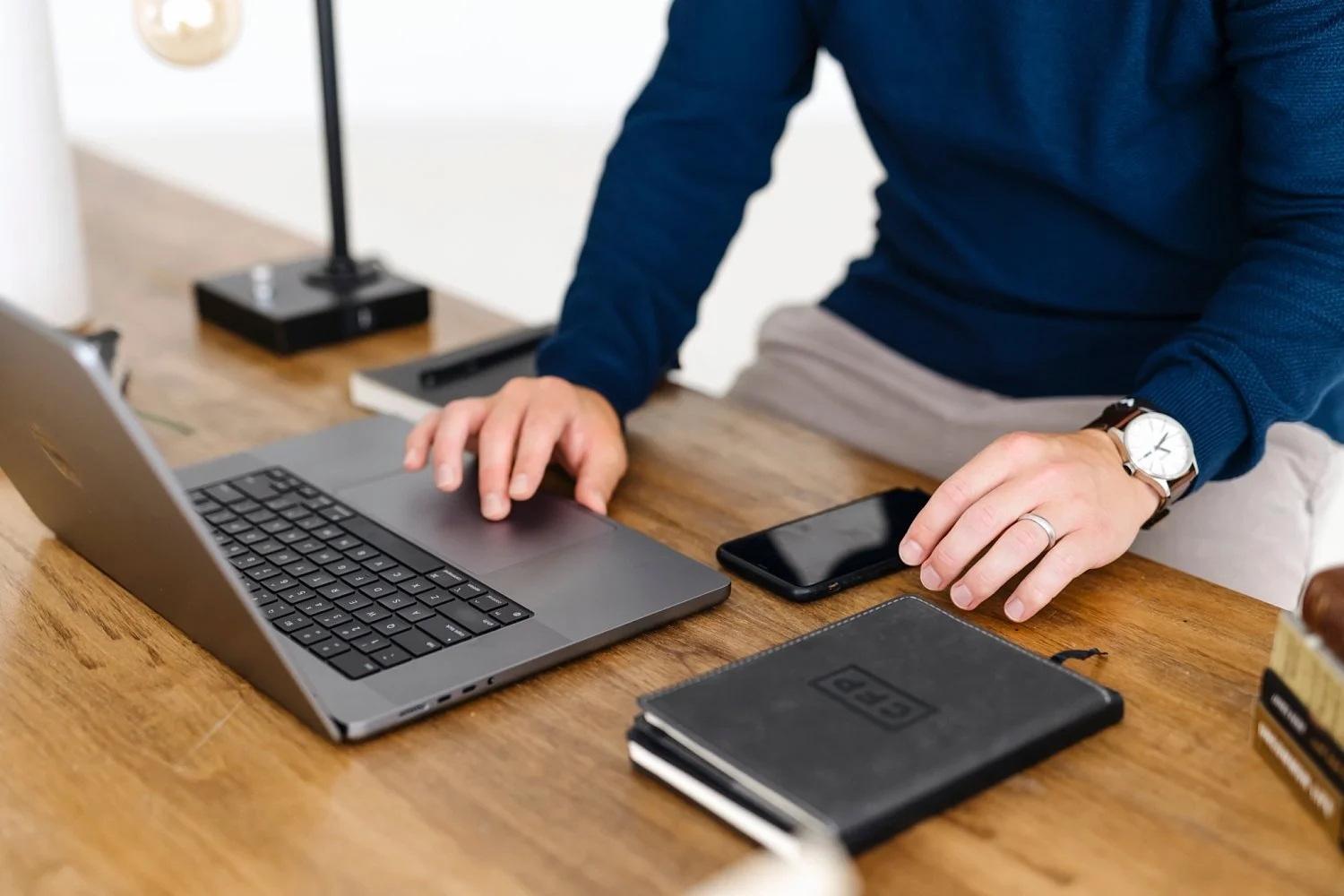 male business owner working on laptop close up of hands and desk