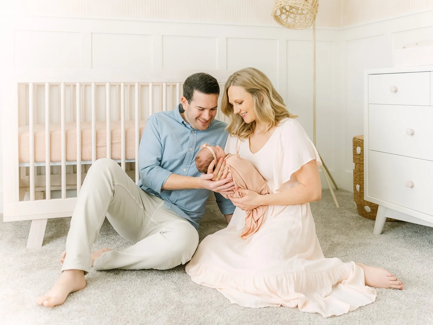 parents holding newborn baby girl in nursery for photos in allen texas