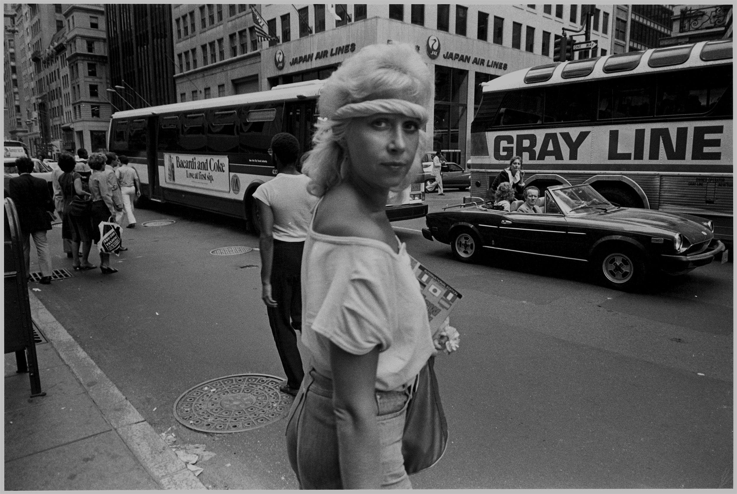 blonde with headband + grayline bus, 5th ave., nyc, mid 1980’s