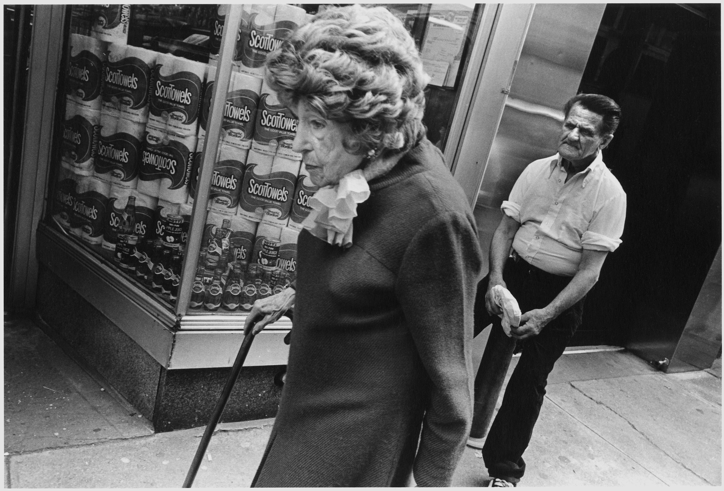 elder woman with cane, man looks on, 57th st., nyc, c. 1987