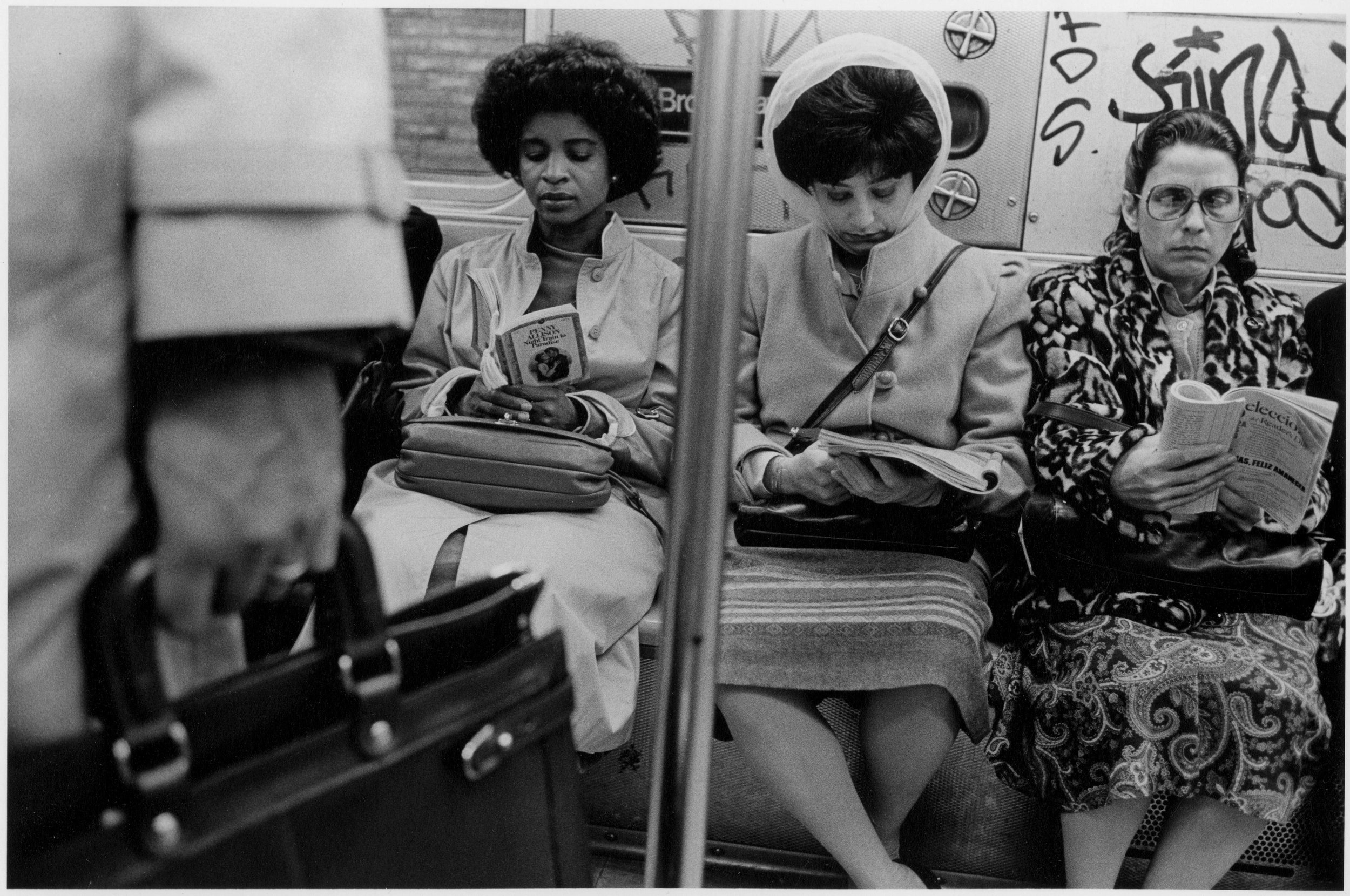 3 women read books on subway, nyc, early 1980’s