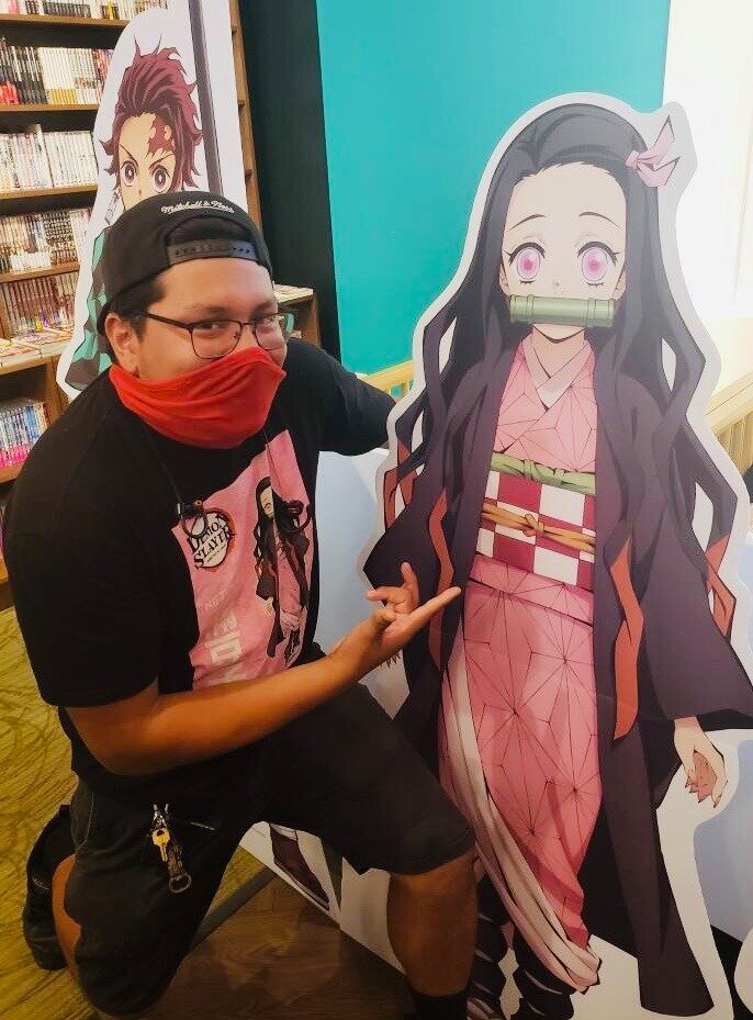 A fan poses with a standee