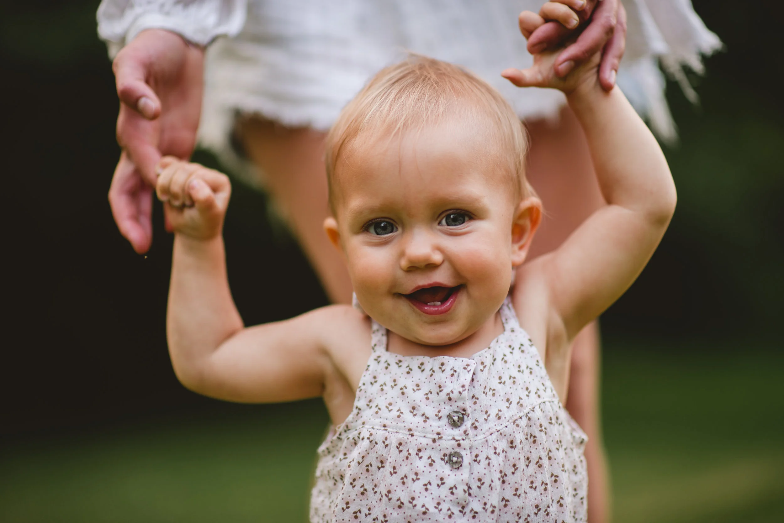 one year old smiling and walking in the woods