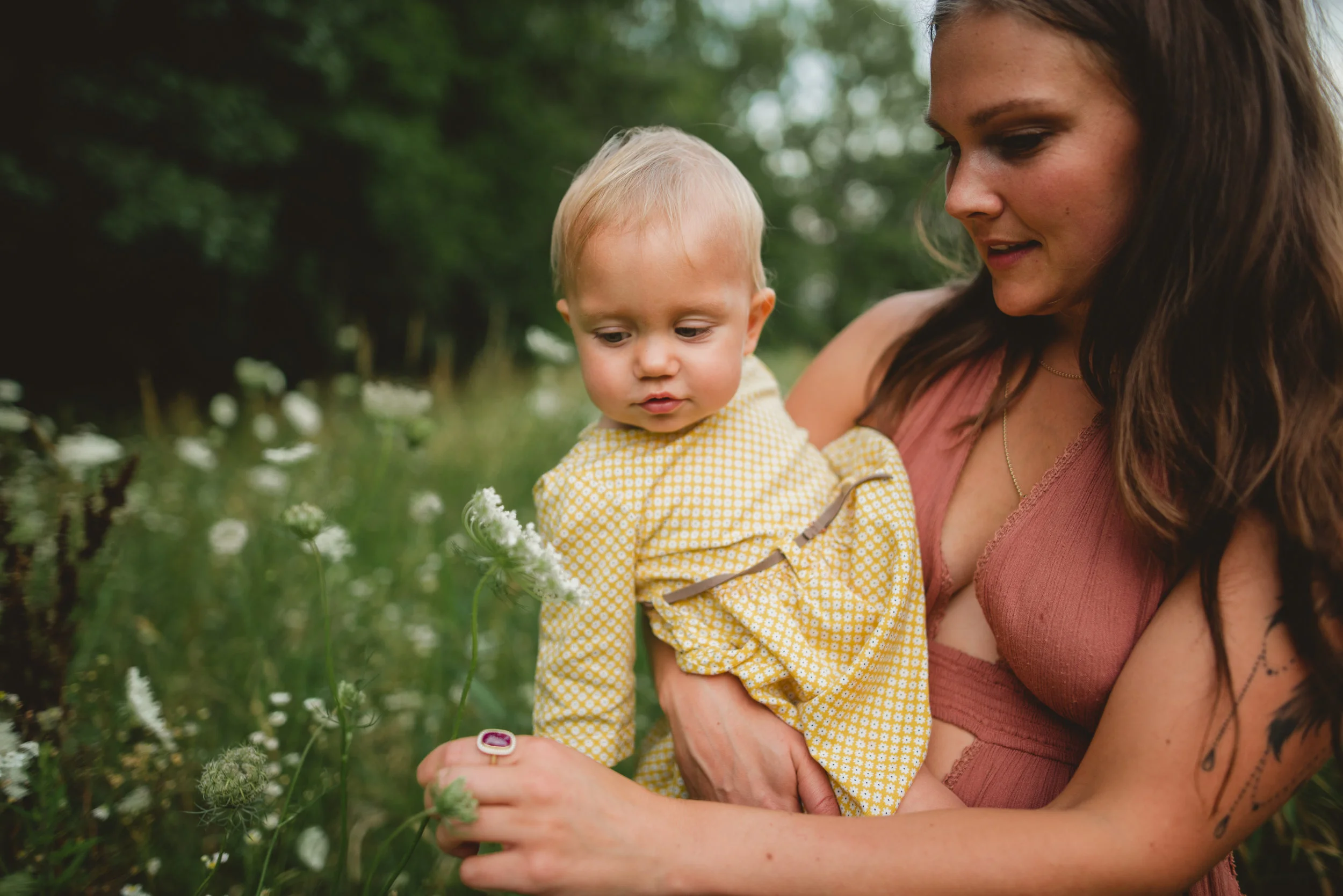 one year old and mommy smelling flowers