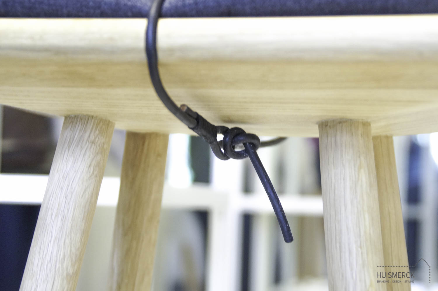 Mooi detail van de leren veter onder de zitting van de Georg Stool