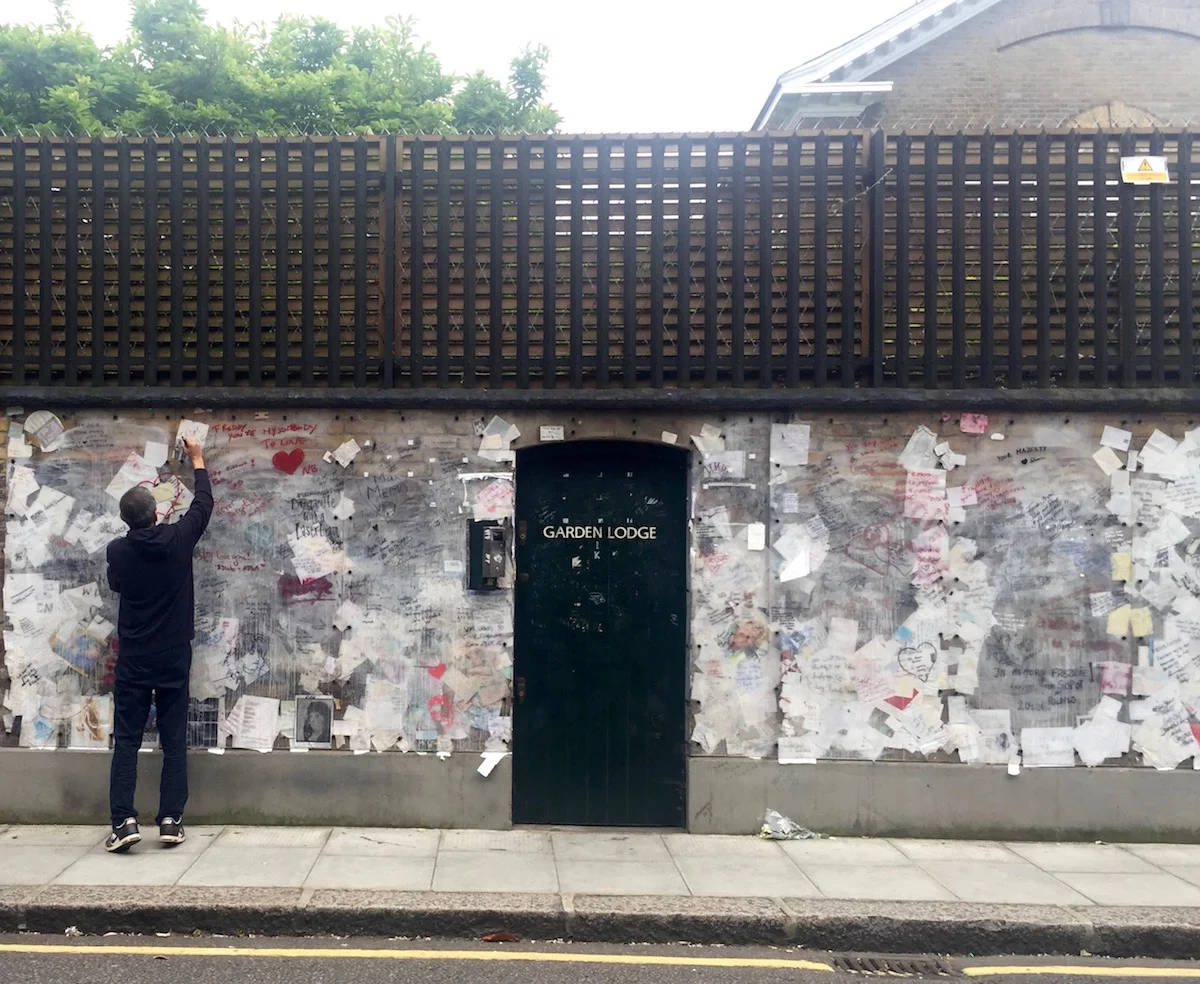 Signing the wall and paying tribute to Freddie Mercury at his former home. Logan Place, Kensington.
