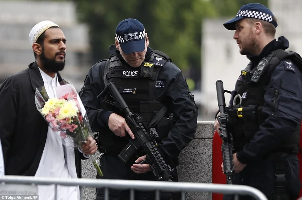 Muslim carrying flowers while police officers carry machine guns.