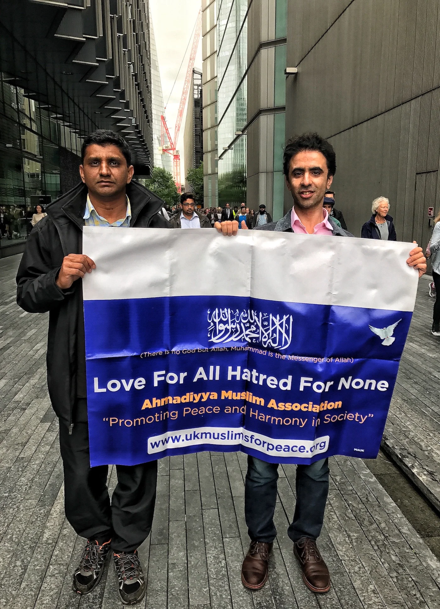 Two Muslim men carrying a sign, Love For All, Hatred For None