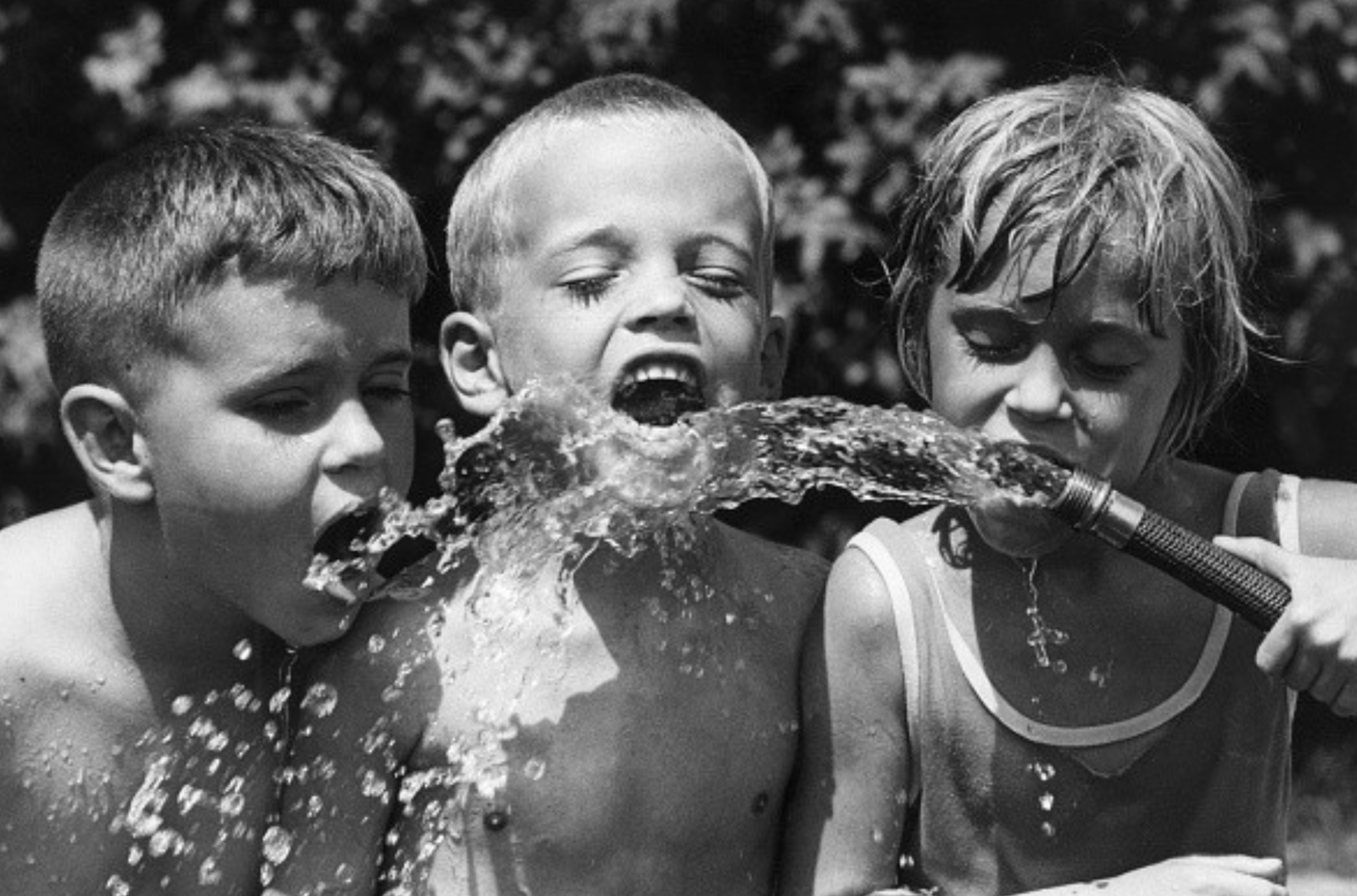 3 kids drinking from hose.png