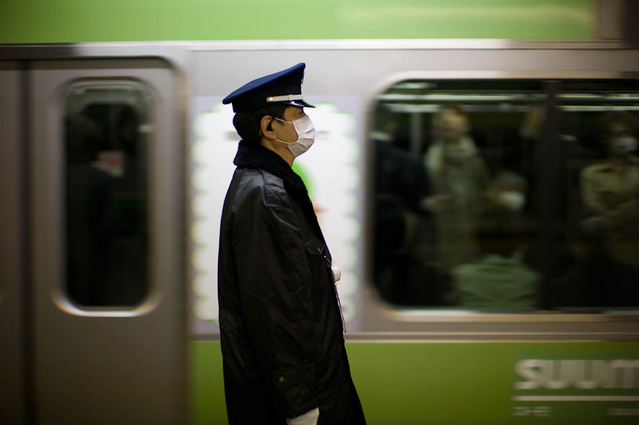 A train conductor as the train passes in Tokyo, Japan
