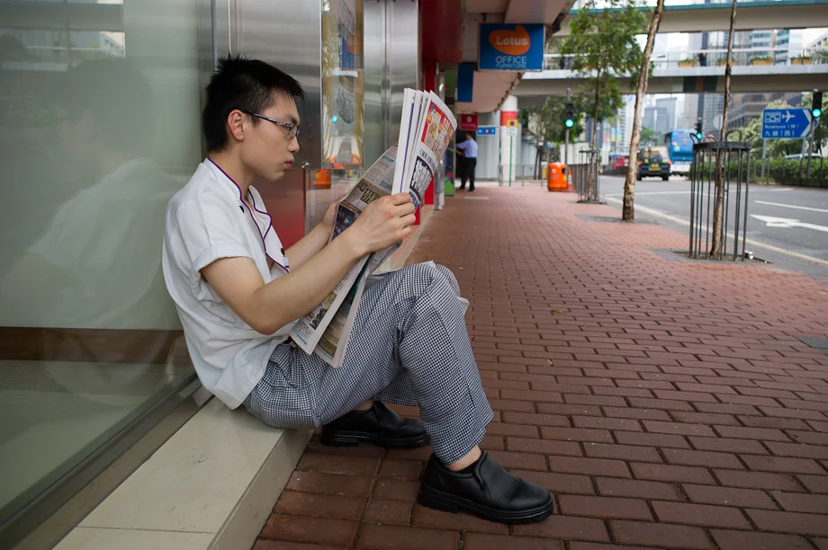 A man reading a newspaper in Hong Kong