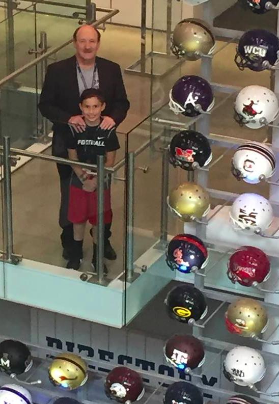 Author, speaker and NCAA record holder, Dr. Emmet C. (Tom) Thompson II, and his son, Jon Rawles,, look out over a collection of helmets at the College Football Hall of Fame in Atlanta. (Dr. Emmet C. (Tom) Thompson II photo)
