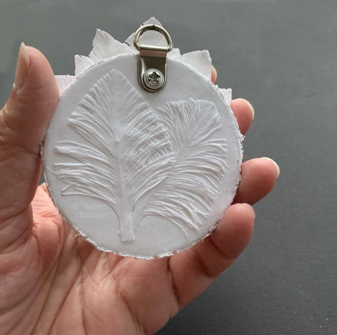 back view - showing the D Ring that is used to attach the small 3 inch round paper sculpture to your wall.