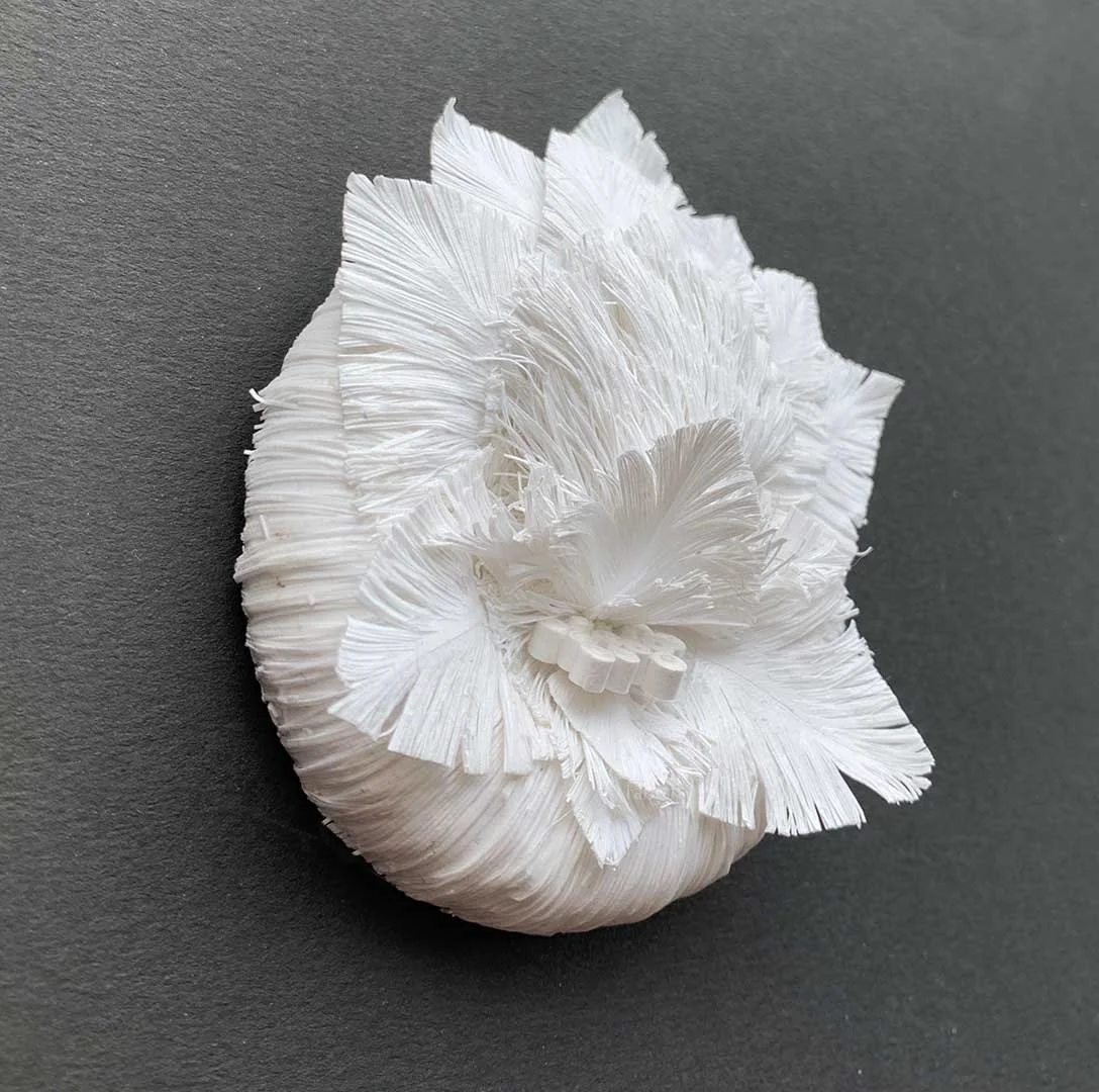 Side View showing depth and texture of the the white hand cut paper sculpture