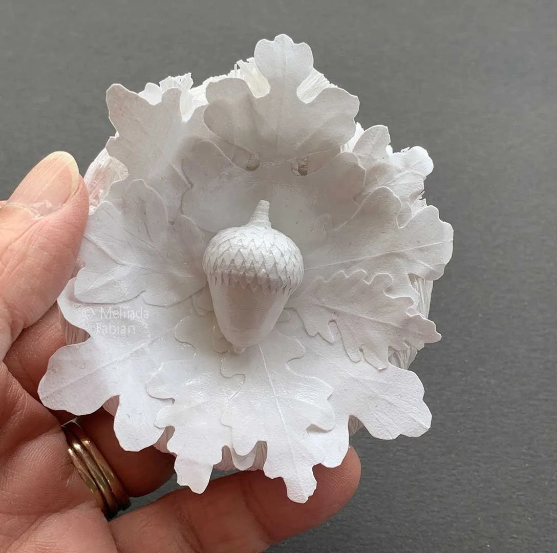 Small one of a kind handmade paper sculpture of a paper acorn surrounded by oak leaves. Small enough to hold in your hand.